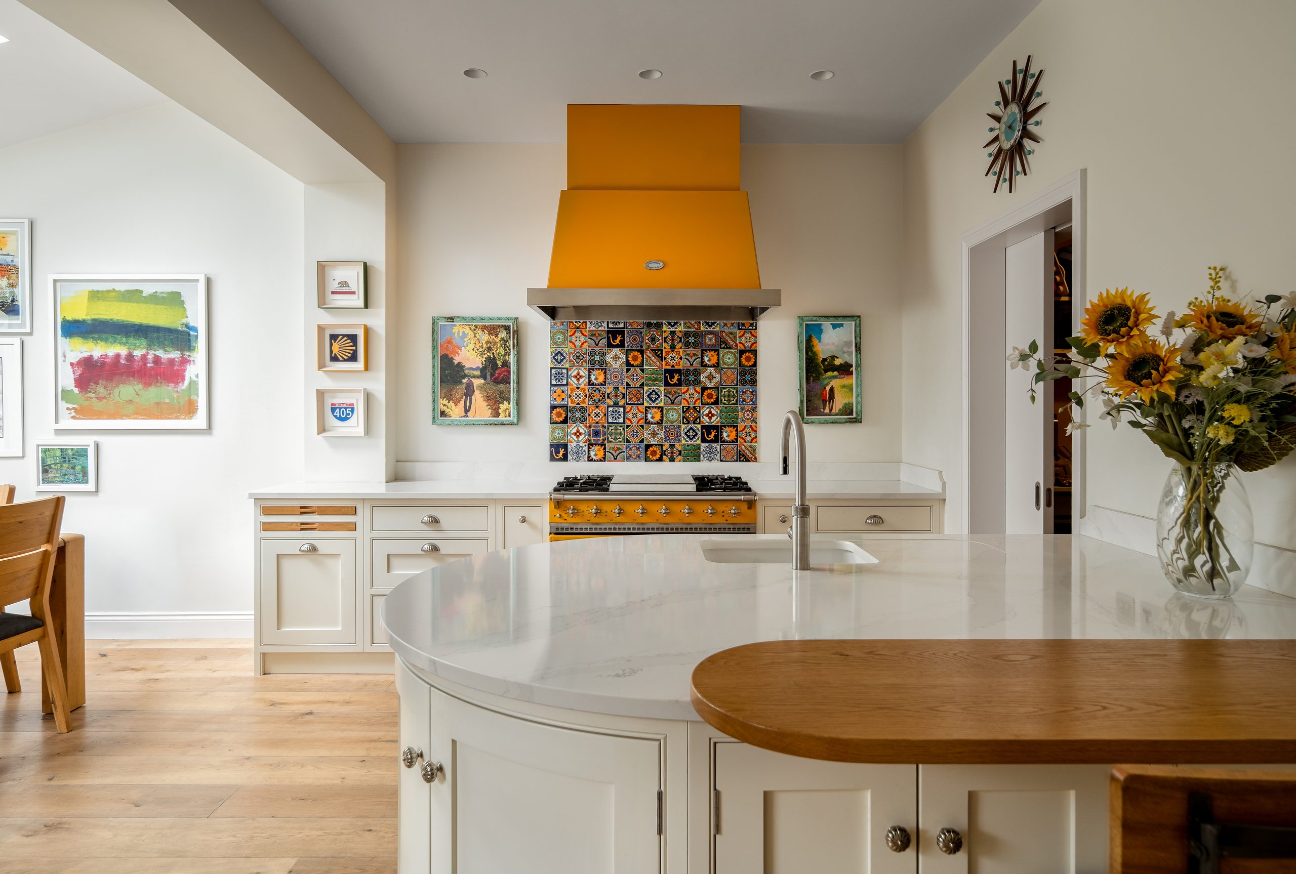 Bespoke cream in-frame Shaker kitchen in Kinsale with curved peninsula and yellow Lacanche range