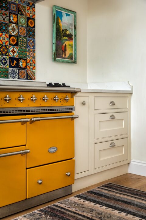Yellow Lacanche range alongside cream in-frame Shaker drawers